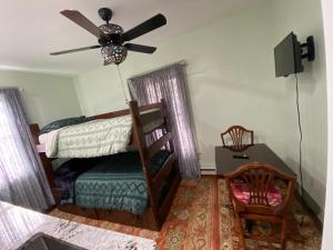 a bedroom with a bed and a ceiling fan at Must See Okemo Mountain Resort in Springfield +7 photos