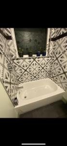 a white bath tub in a bathroom with tiles at Must See Okemo Mountain Resort in Springfield