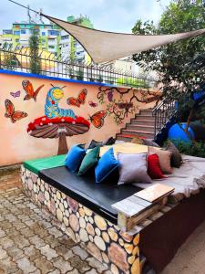 a bench with colorful pillows on it next to a wall at Villa Villekulla in Tirana +34 photos
