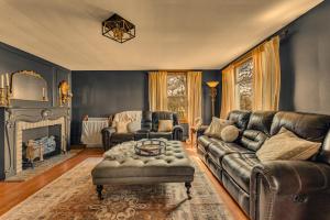 a living room with a leather couch and a table at The John Collins House in Canfield
