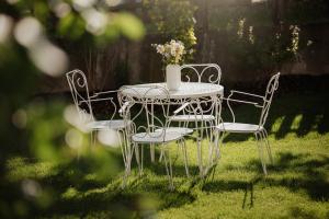 a table and chairs with a vase of flowers on it at Villa Melitta in San Vigilio Di Marebbe