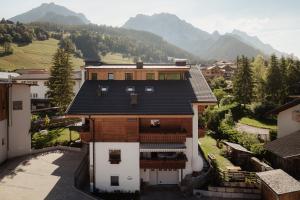 a house in a village with mountains in the background at Villa Melitta in San Vigilio Di Marebbe