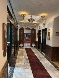 a hallway with a red carpet in a building at Amor Hotel in Fez