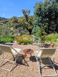 two chairs and a table in a garden at Finca Bravo in Cortegana