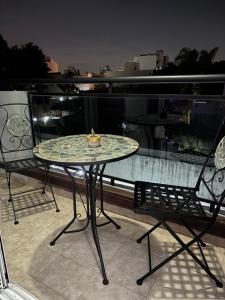 a glass table and two chairs on a balcony at Ballester apart piscina in Villa Ballester