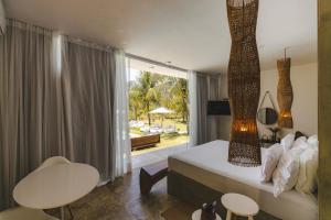 a bedroom with a bed and a table and chairs at Pe na Areia Boutique Hotel in Japaratinga +146 photos