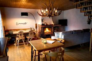 a living room with a table and a fireplace at Haus Sommerseit'n Ruhe-Natur-Genuss in Hirschbach