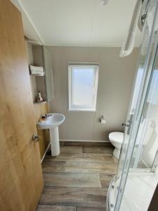 a bathroom with a sink and a toilet and a window at Fleece Lodge in Bledington +7 photos