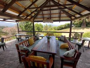 a wooden table and chairs on a patio at De Molen Guest House in Somerset West