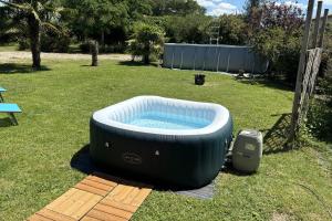 a hot tub sitting on the grass in a yard at Le cocon près d'Albi in Saint-Grégoire