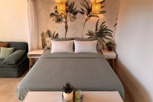 a bedroom with a bed with two tables and a couch at Le cocon près d'Albi in Saint-Grégoire