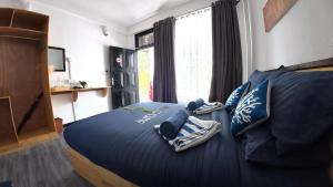 a bedroom with a bed with blue sheets and pillows at Adroit Sunset View in Guraidhoo