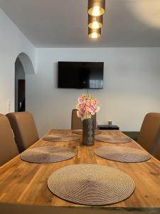 a table with four chairs and a vase of flowers on it at EDGE of FOREST in Titisee-Neustadt