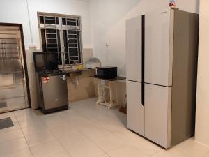 a kitchen with a large refrigerator and a sink at SWee Garden Homestay in Kota Tinggi