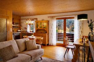 a living room with a couch and a table and a kitchen at Haus Sommerseit'n Ruhe-Natur-Genuss in Hirschbach