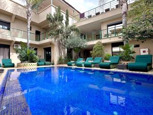 a swimming pool with blue chairs and a building at Bab louka in Aït Bou Zguia
