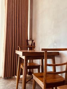 a wooden table and two chairs and a curtain at Viora Lodge in Nuwara Eliya +10 photos