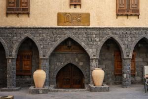 a building with three large vases in front of it at بوتيك خان عطره in Medina