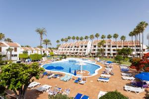 a resort with a pool and chairs and palm trees at Ocean Mark Holiday Parque Santiago 2 in Playa de las Americas