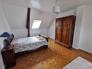 a bedroom with a bed and a wooden cabinet at Maisonnette au calme in Sully-sur-Loire