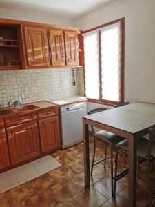 a kitchen with wooden cabinets and a table with chairs at Maisonnette au calme in Sully-sur-Loire +3 photos