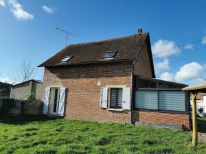 an old brick house on a grassy hill at Maisonnette au calme in Sully-sur-Loire