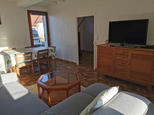 a living room with a couch and a tv at Maisonnette au calme in Sully-sur-Loire