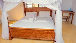 a bedroom with a bed with a canopy at AMOODY MANZIl in Shela