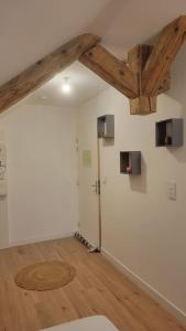 a room with white walls and wooden beams at Les sapins 201 in Charquemont