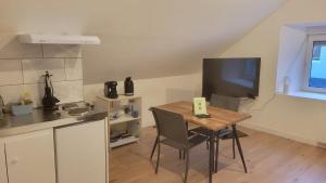 a small kitchen with a table and a television at Les sapins 201 in Charquemont