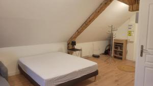 a bedroom with a white bed in a attic at Les sapins 201 in Charquemont