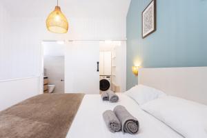 a bedroom with a white bed with towels on it at Ocean Mark Holiday Parque Santiago 2 in Playa de las Americas +23 photos