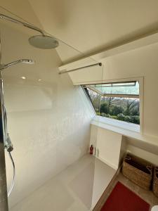 a bathroom with a shower and a window at Nid douillet Les Mouettes in Fouesnant
