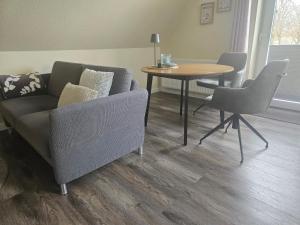 a living room with a couch and a table at Moderne Ferienwohnung "Adriane" mit gehobener Ausstattung - Top bewertet in Nordhorn