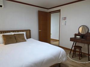 a bedroom with a bed and a dressing table and a mirror at Wizday Stay in Suwon