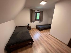an attic room with a bed and a window at Domki Mucharskie in Mucharz