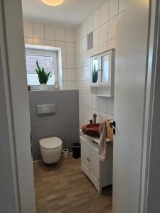 a bathroom with a toilet and a sink at Privatunterkunft Bingum in Leerort