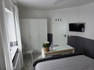 a bedroom with a bed and a desk and a television at Privatunterkunft Bingum in Leerort