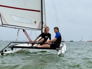 a man and woman sitting on a sailboat in the water at Nid douillet Les Mouettes in Fouesnant