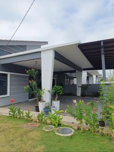 a house with awning and plants in a yard at Dirindu homestay in Temerloh