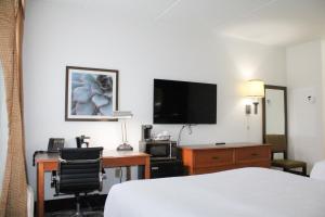 a hotel room with a bed and a desk and a television at La Quinta by Wyndham Lakeland East in Lakeland