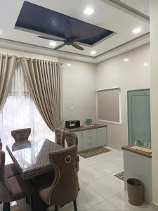 a dining room with a table and a ceiling fan at Dirindu homestay in Temerloh