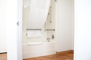 a bathroom with a tub and a shower with a towel at La Quinta by Wyndham Lakeland East in Lakeland