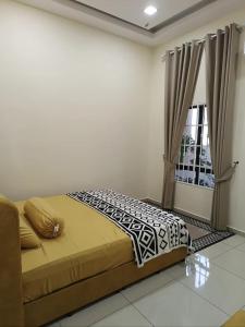 a bedroom with a bed and a window at Dirindu homestay in Temerloh