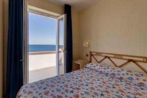a bedroom with a bed and a view of the ocean at Appartamenti - Villa Mare in Pomonte