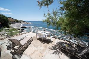 a patio with a table and chairs and the ocean at Appartamenti - Villa Mare in Pomonte
