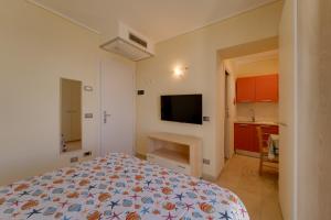 a bedroom with a bed and a flat screen tv at Appartamenti - Villa Mare in Pomonte