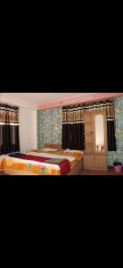 a bedroom with two beds and a mirror and curtains at Hotel Sangla Retreat in Sāngla