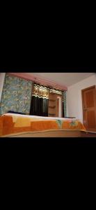 a bedroom with a bed and a window with curtains at Hotel Sangla Retreat in Sāngla