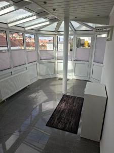 a large room with windows and a rug on the floor at Ferienwohnung Am Anger in Unterleinach